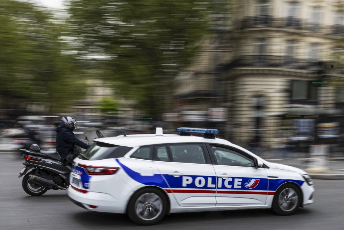 Photo used for representational purposes. A French police officer drives a police car next to a scooter on a street in Paris on April 16, 2025. Photo by Sébastien DUPUY / AFP.