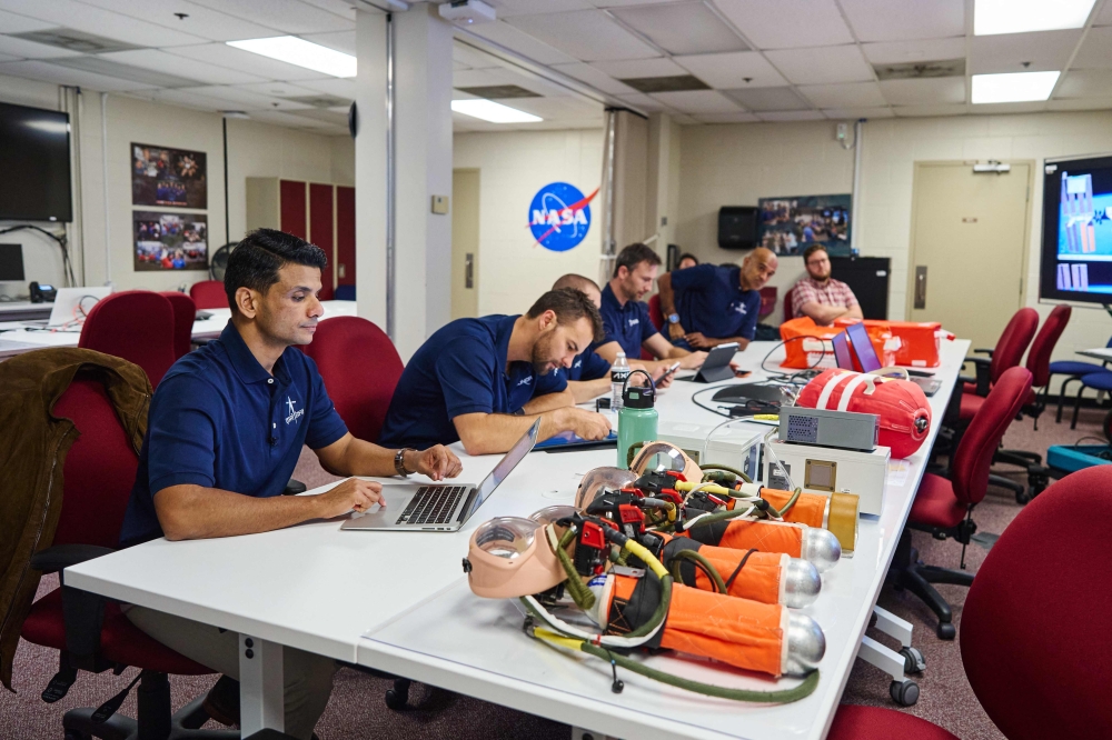 This handout photograph taken on September 12, 2024 and released by private aerospace company Axiom Space shows assigned and backup Ax-4 crew members (L to 2nd R) Shubhanshu Shukla, Tibor Kapu, Gyula Cserenyi (partly obscured), Slawosz Uznanski, and Prasanth Nair reviewing materials during emergency fire training at NASA's Johnson Space Center (JSC) in Houston, Texas. (Photo by AXIOM SPACE / AFP) 