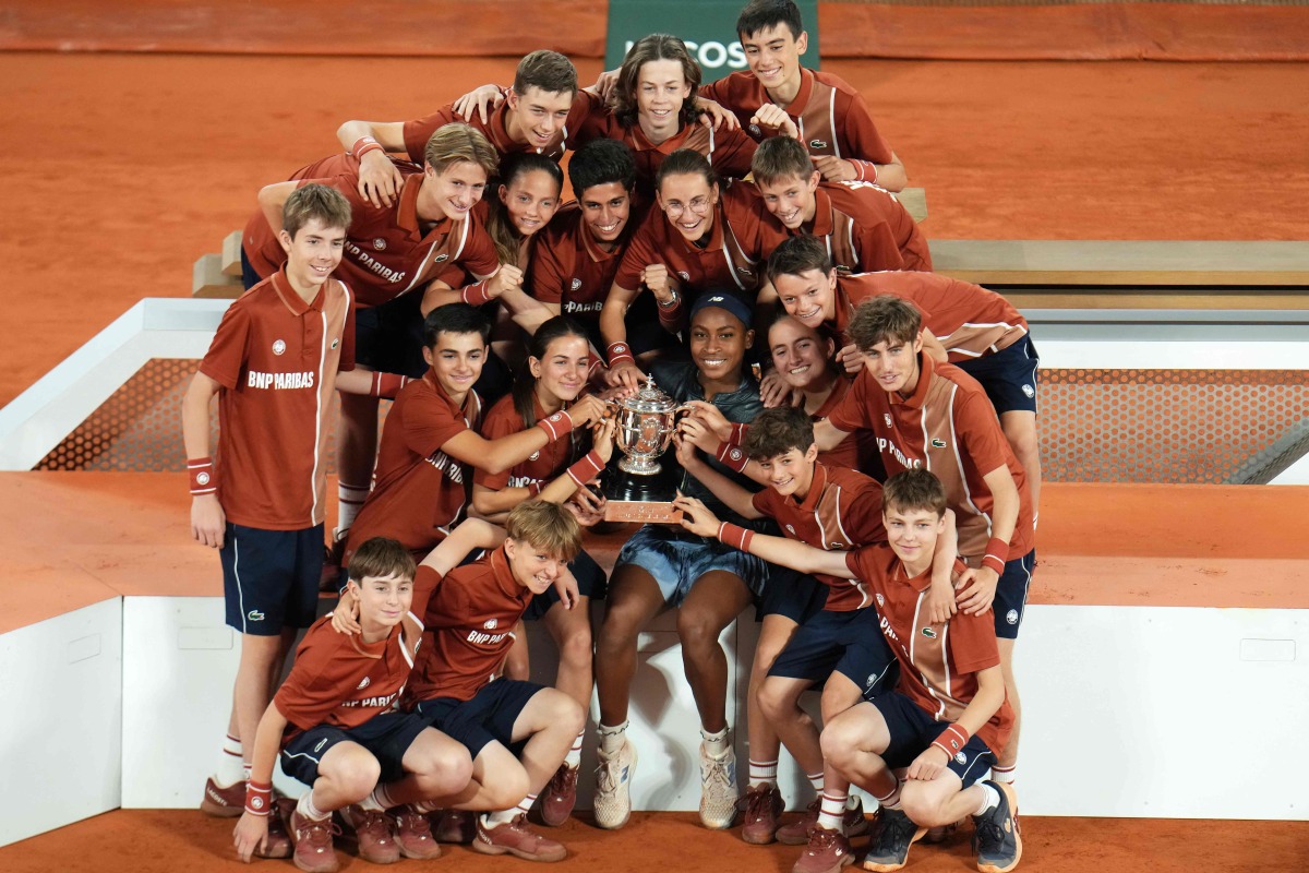 Coco Gauff of the US poses with the ball boys and ball girls after winning the French Open women's singles title.
