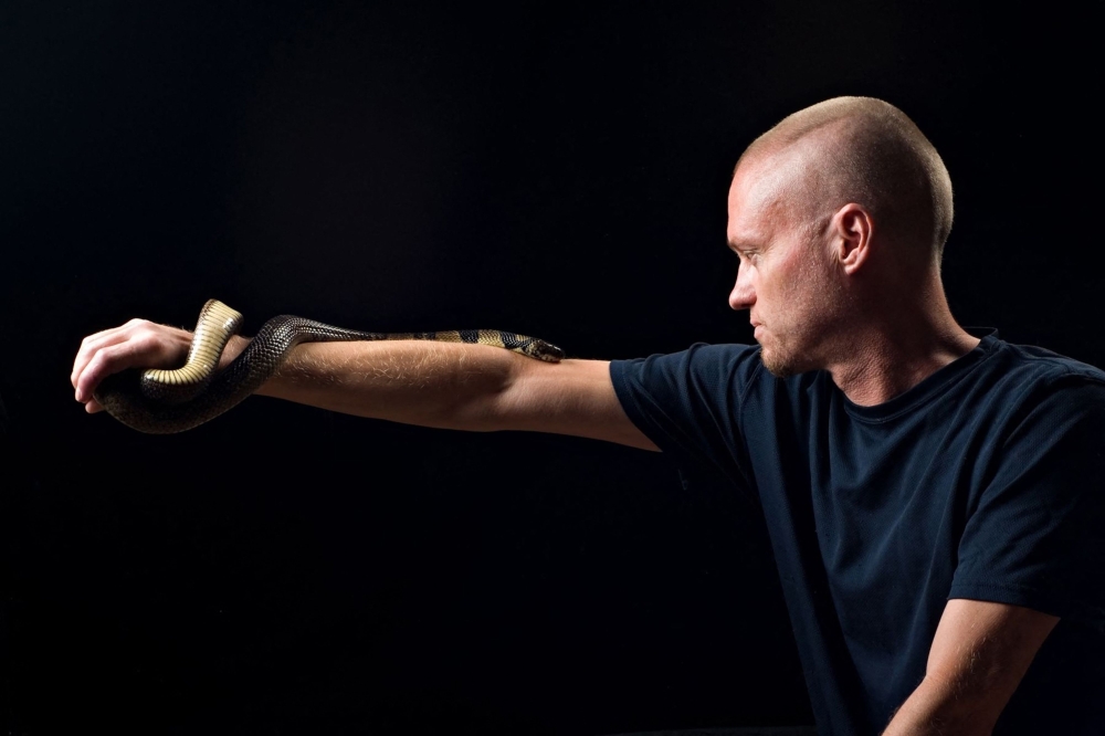 This undated handout photograph obtained from Centivax on May 30, 2025, shows US' Tim Friede posing with a water cobra. (Photo by CENTIVAX / AFP)