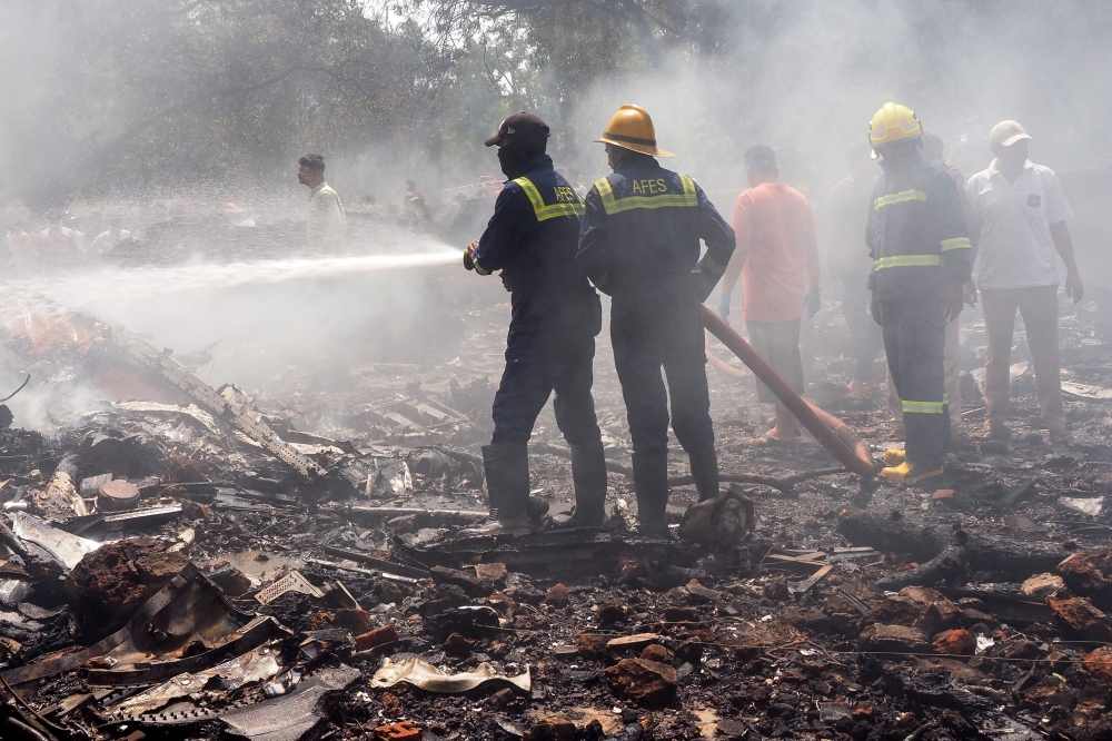 Firefighters work at the site where Air India flight 171 crashed in a residential area near the airport in Ahmedabad on June 12, 2025. (Photo by Sam Panthaky / AFP)