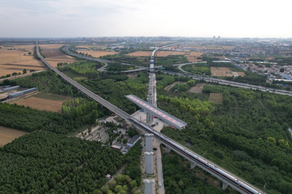 A swivel bridge along Xiong'an-Baoding section of Xiong'an-Xinzhou high-speed railway before rotating to its desired position over Beijing-Guangzhou high-speed railway in Baoding, north China's Hebei Province, on June 17, 2025. (Xinhua/Xing Guangli)