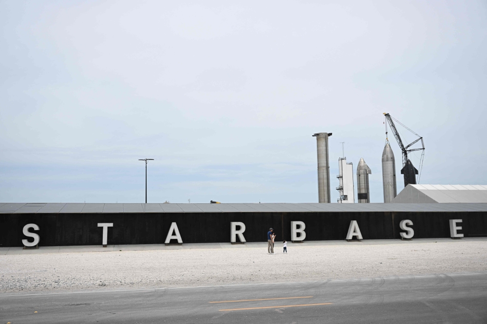 (Files) People take pictures of the rocket garden ahead of the SpaceX Starship flight test from Starbase in Boca Chica, Texas on April 16, 2023. (Photo by Patrick T. Fallon / AFP)