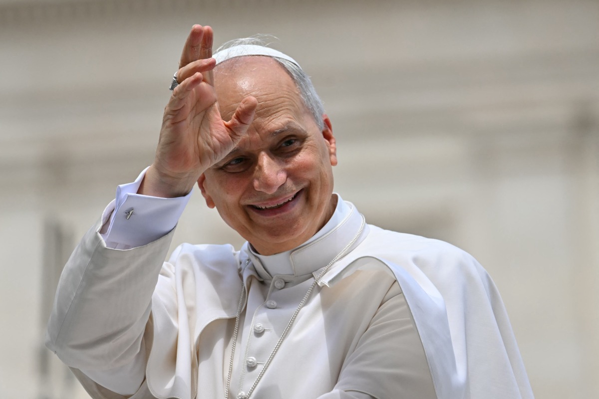 Pope Leo XIV waves to the crowd at the end of a weekly general audience at St Peter's Square in The Vatican on June 18, 2025. (Photo by Andreas SOLARO / AFP)
