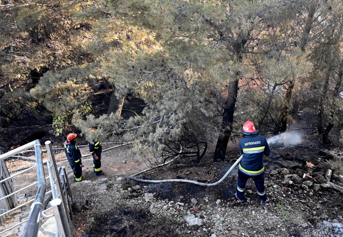 Croatian firefighters operate water hoses and other equipment during a wildfire near the coastal town of Omis on June 21, 2025. (Photo by ELVIS BARUKCIC / AFP)