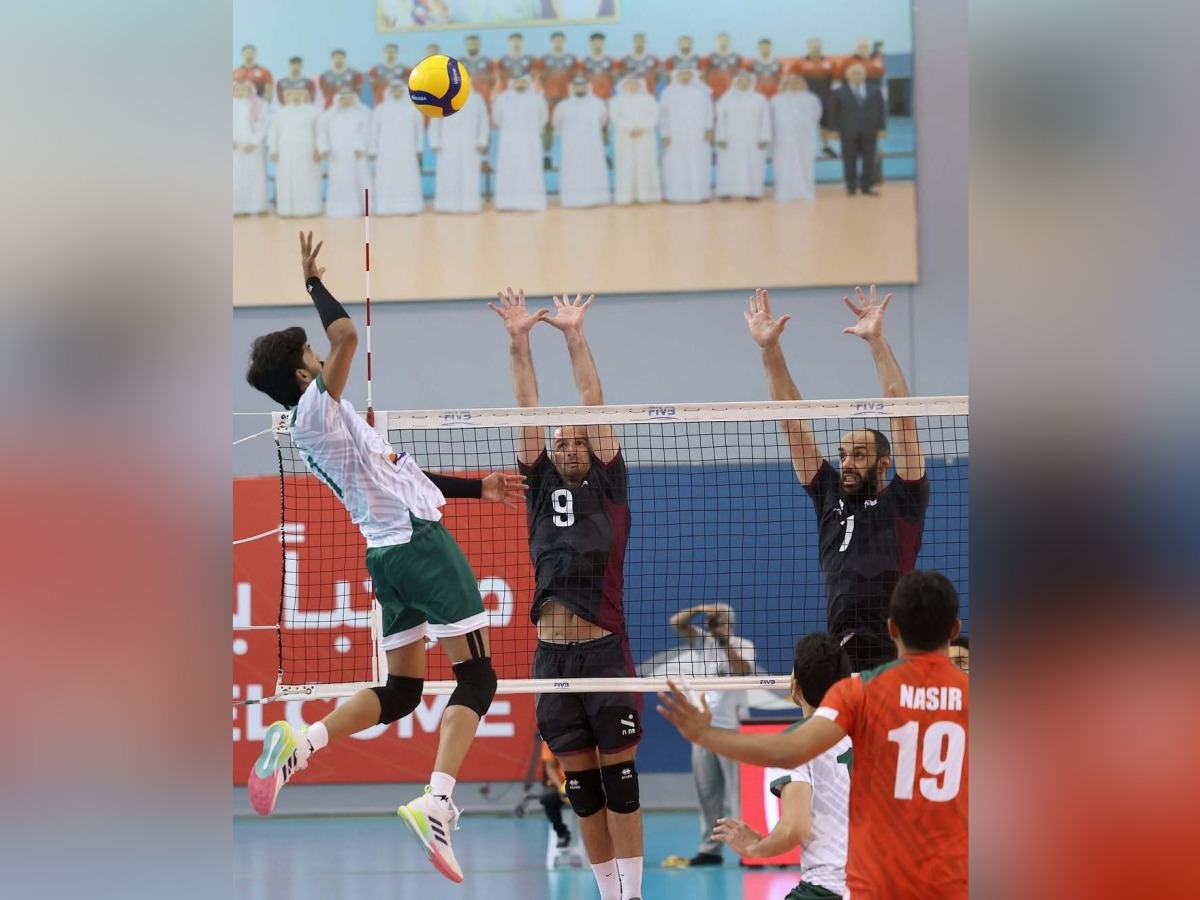 A Pakistan player hits a shot as Qatar players prepare to block.