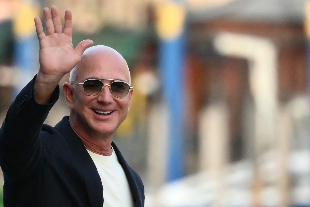 US founder of Amazon, Jeff Bezos waves as he leaves the Aman Hotel in Venice on June 25, 2026. (Photo by Marco Bertorello / AFP)