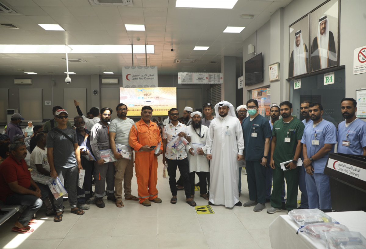 Some of the participating workers with QCS officials in a group photo during the campaign.