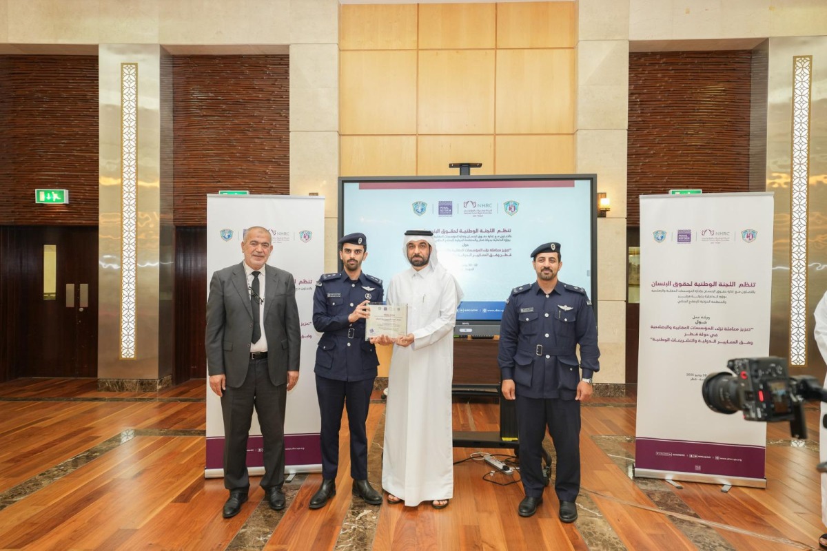 Secretary-General of the National Human Rights Committee Sultan bin Hassan Al-Jamali (second right) presenting a certificate to one of the participants.