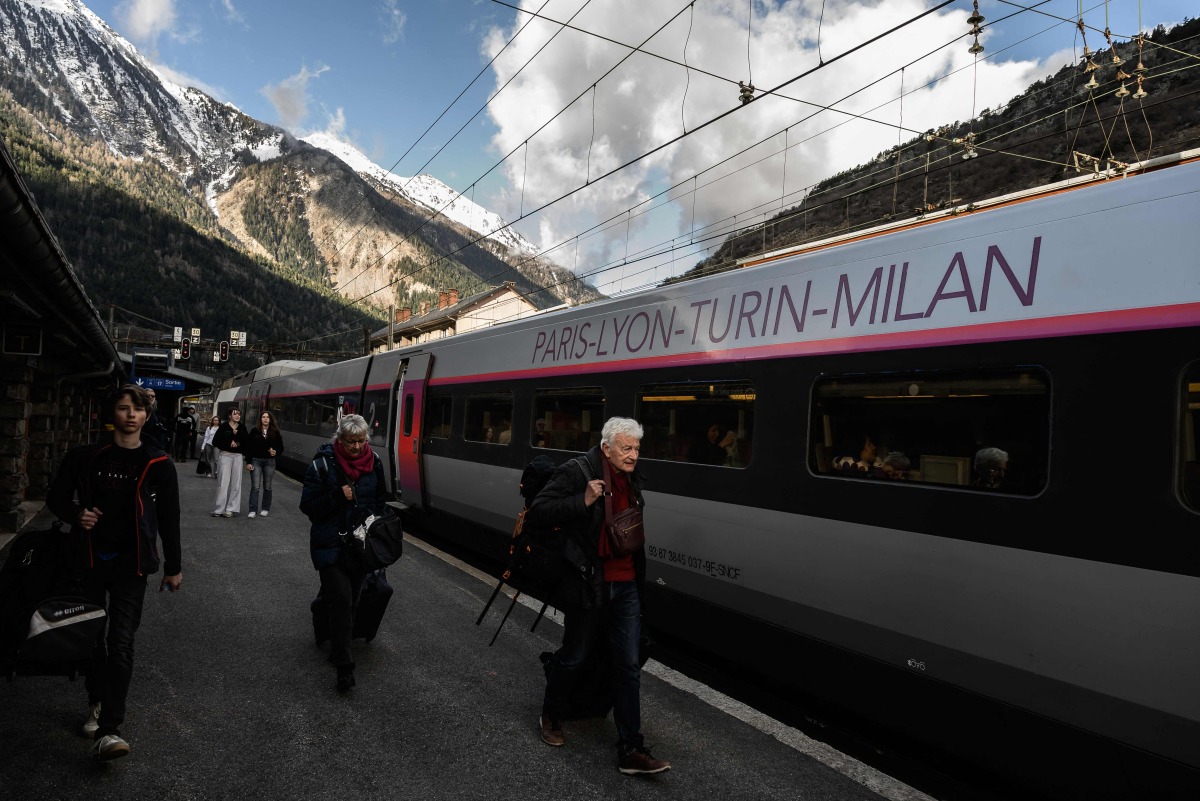 Passengers walk along a platform as train services between Modane and Saint-Michel-de-Maurienne resumed, at Modane train station in Modane, in the French Alps, on March 31, 2025. Photo by JEAN-PHILIPPE KSIAZEK / AFP