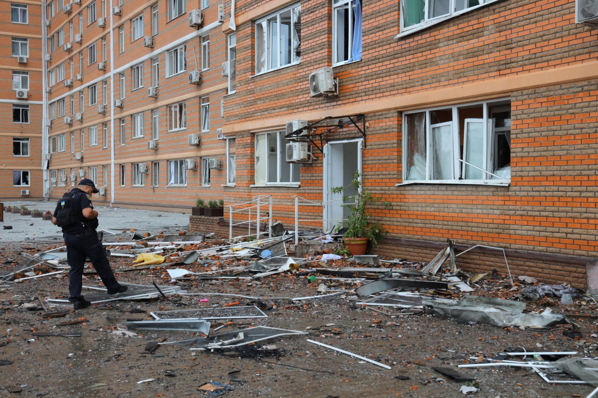 A policeman inspects debris at the bottom of a multi-storey residential building, which was damaged after a Russian drone attack in Odesa on June 28, 2025, amid the Russian invasion of Ukraine. Photo by Oleksandr GIMANOV / AFP.