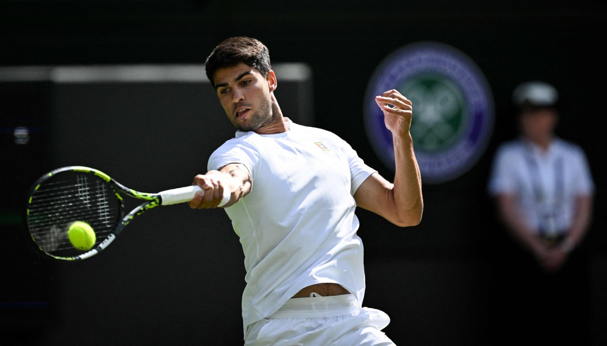 Spain's Carlos Alcaraz plays a forehand return to Britain's Oliver Tarvet during their men's singles second round tennis match on the third day of the 2025 Wimbledon Championships at The All England Lawn Tennis and Croquet Club in Wimbledon, southwest London, on July 2, 2025. (Photo by Kirill KUDRYAVTSEV / AFP)