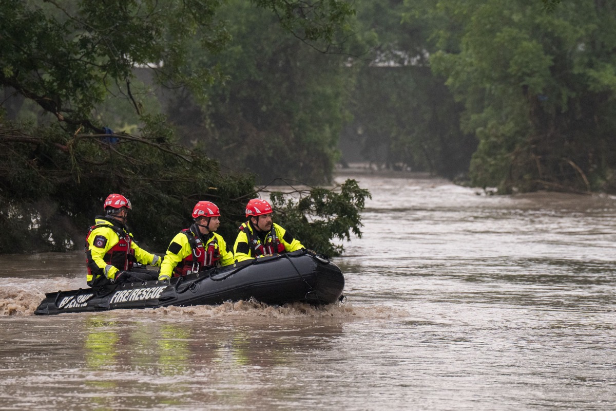 Boerne Search and Rescue teams navigate upstream in an inflatable boat on the flooded Guadalupe River on July 4, 2025 in Comfort, Texas. Heavy rainfall caused flooding along the Guadalupe River in central Texas with multiple fatalities reported. (Photo by Eric Vryn / GETTY IMAGES NORTH AMERICA / Getty Images via AFP)