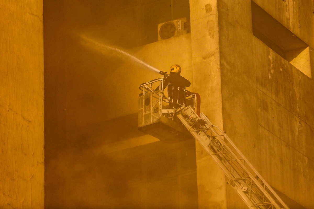 A firefighter douses the flames after a fire broke out in the Telephones landline exchanging station and Ministry of Communications building in the heart of Cairo on July 7, 2025. Photo by AFP