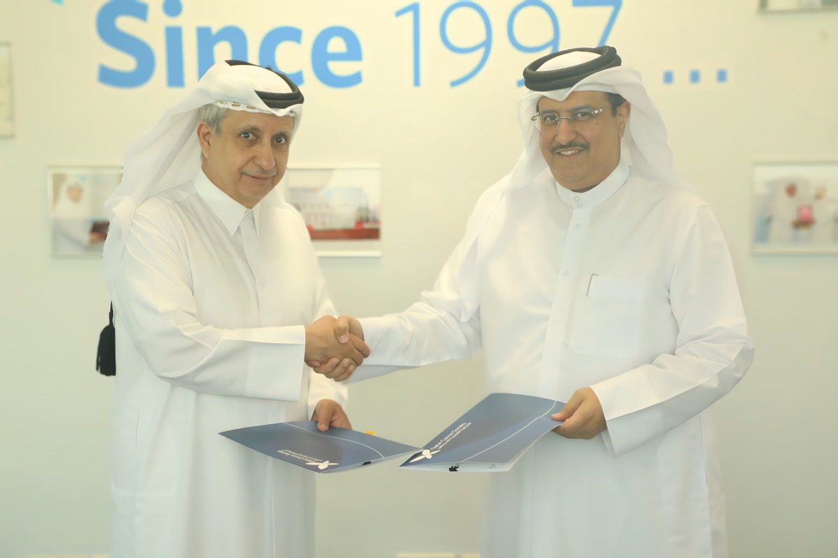 QCS Chairman Dr. Khalid bin Jabor Al Thani and Director of Al-Khaldi Law Firm Saleh Ali Al-Khaldi exchanging documents after signing the agreement.