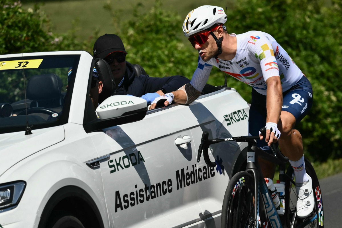 Team TotalEnergies' French rider Emilien Jeanniere cycles alongside the medical assistance vehicle during the 4th stage of the 112th edition of the Tour de France cycling race, 174.2 km between Amiens Metropole and Rouen, Northern France, on July 8, 2025. (Photo by Marco BERTORELLO / AFP)

