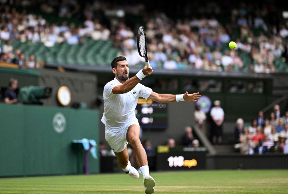 Serbia’s Novak Djokovic plays a forehand return to Italy’s Flavio Cobolli.