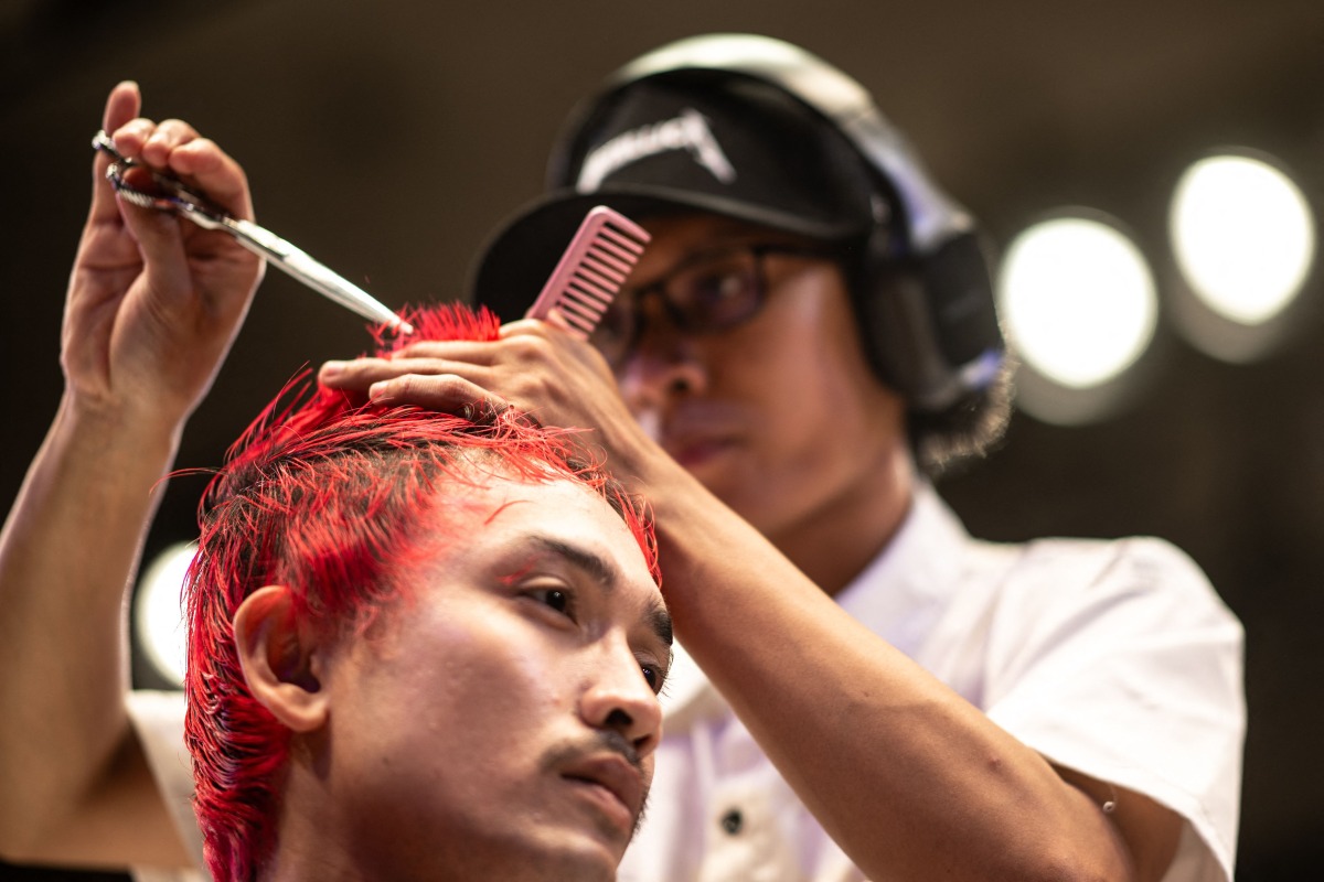 A barber gives a model a haircut during the World Barber Classic at Korakuen Hall in Tokyo on July 14, 2025. (Photo by Philip FONG / AFP)