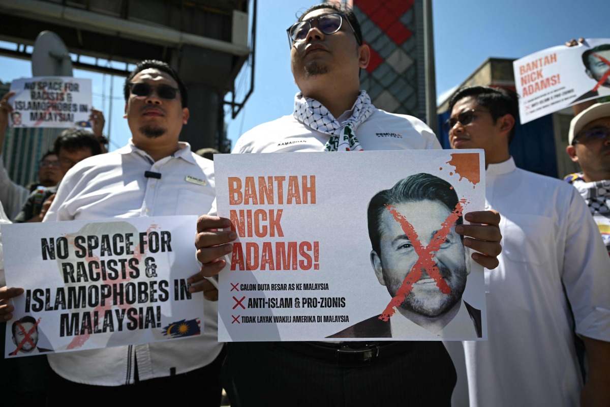 Malaysian protesters display placards during a demonstration against the US envoy nominee Nick Adams outside the US embassy in Kuala Lumpur on July 18, 2025. (Photo by Mohd RASFAN / AFP)
