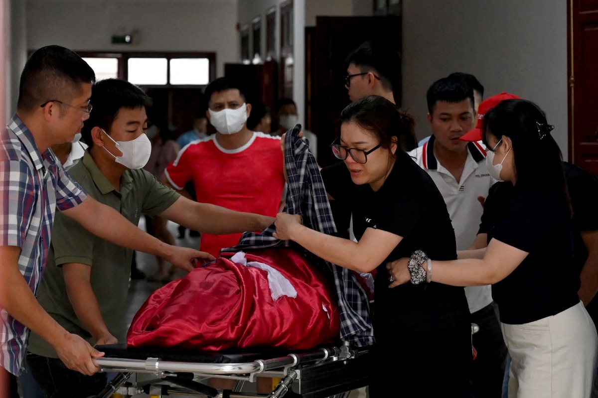 Relatives move the body of a victim after a tourist boat capsized in Ha Long Bay, at a funeral home in Ha Long, Quang Ninh province on July 20, 2025. Photo by Nhac NGUYEN / AFP