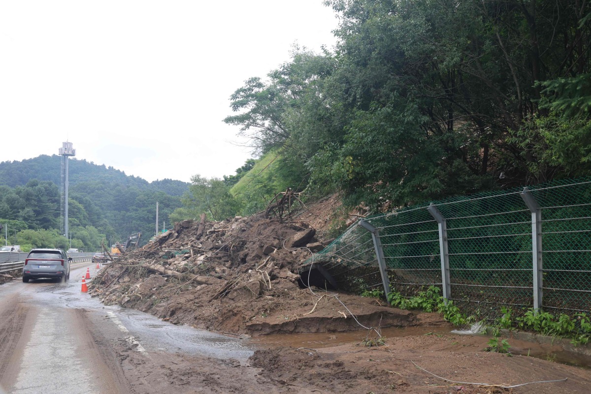 A road is covered with mud and debris carried by a mudslide due to heavy rain in Gapyeong county on July 20, 2025. Photo by YONHAP / AFP