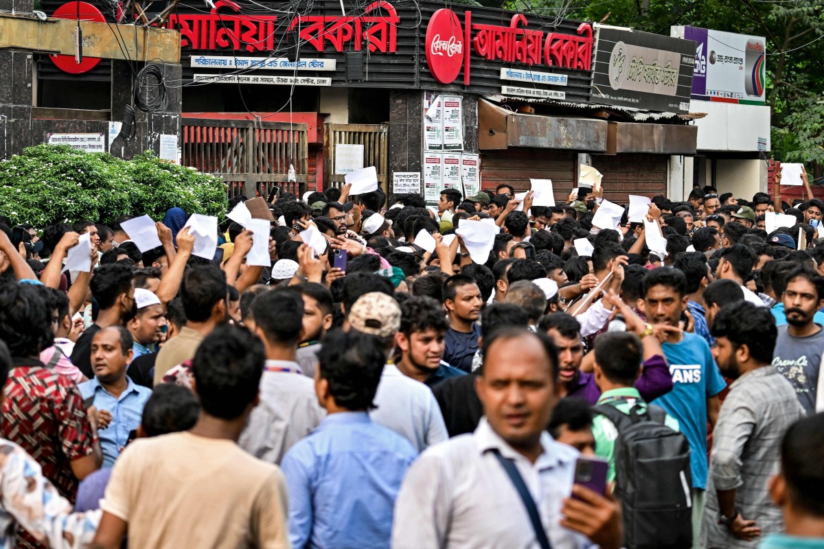 Blood donors gather outside a hospital with documents after an Air Force training jet crashed into a school in Dhaka on July 21, 2025. (Photo by Munir UZ ZAMAN / AFP)