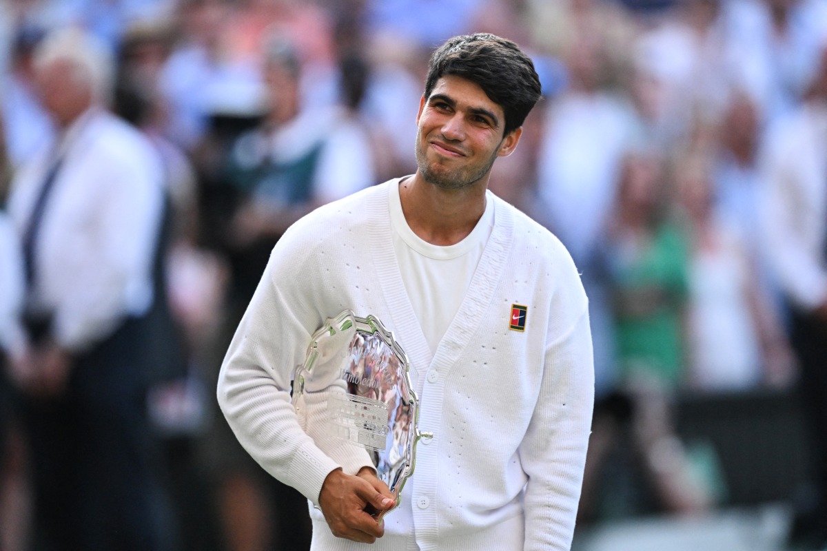 Spain's Carlos Alcaraz poses with the runner's up trophy, following his defeat against Italy's Jannik Sinner at the end of their men's singles final tennis match on the fourteenth day of the 2025 Wimbledon Championships at The All England Lawn Tennis and Croquet Club in Wimbledon, southwest London, on July 13, 2025. (Photo by Kirill KUDRYAVTSEV / AFP)