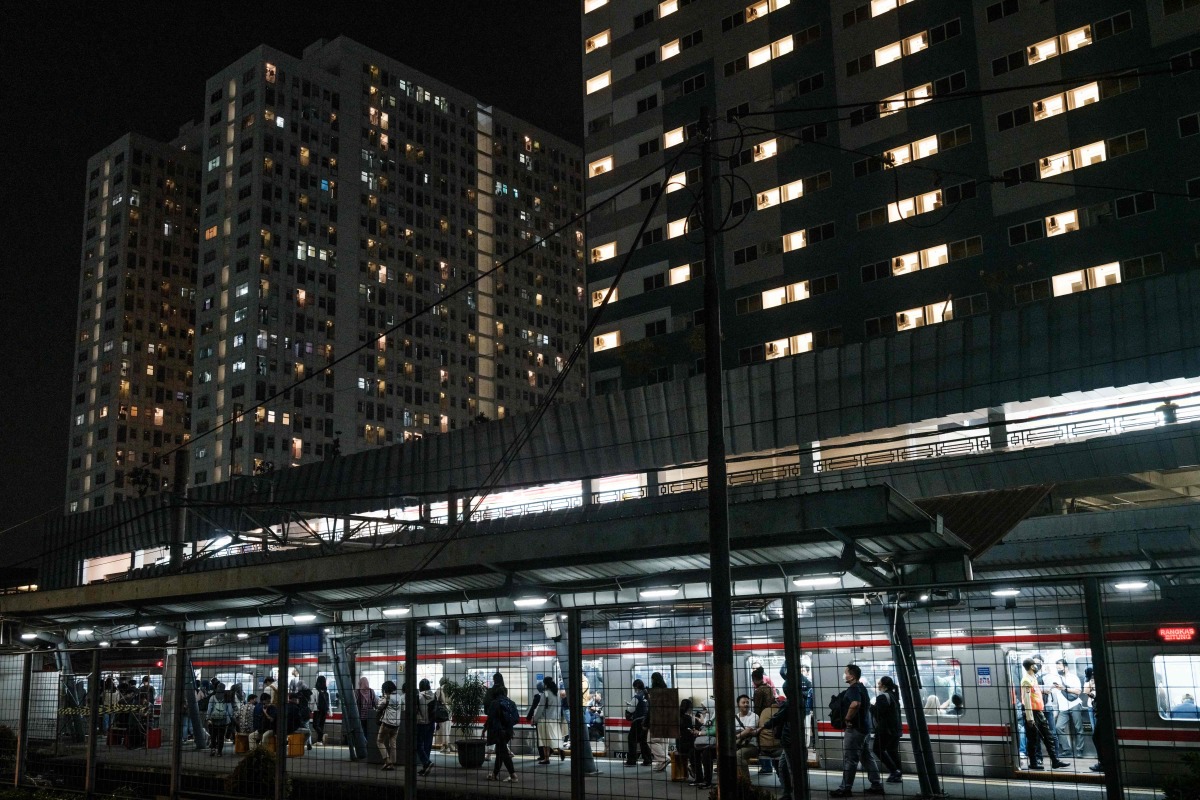 Commuters get off a train at a station in Tangerang, Greater Jakarta, on July 22, 2025. (Photo by Yasuyoshi CHIBA / AFP) 