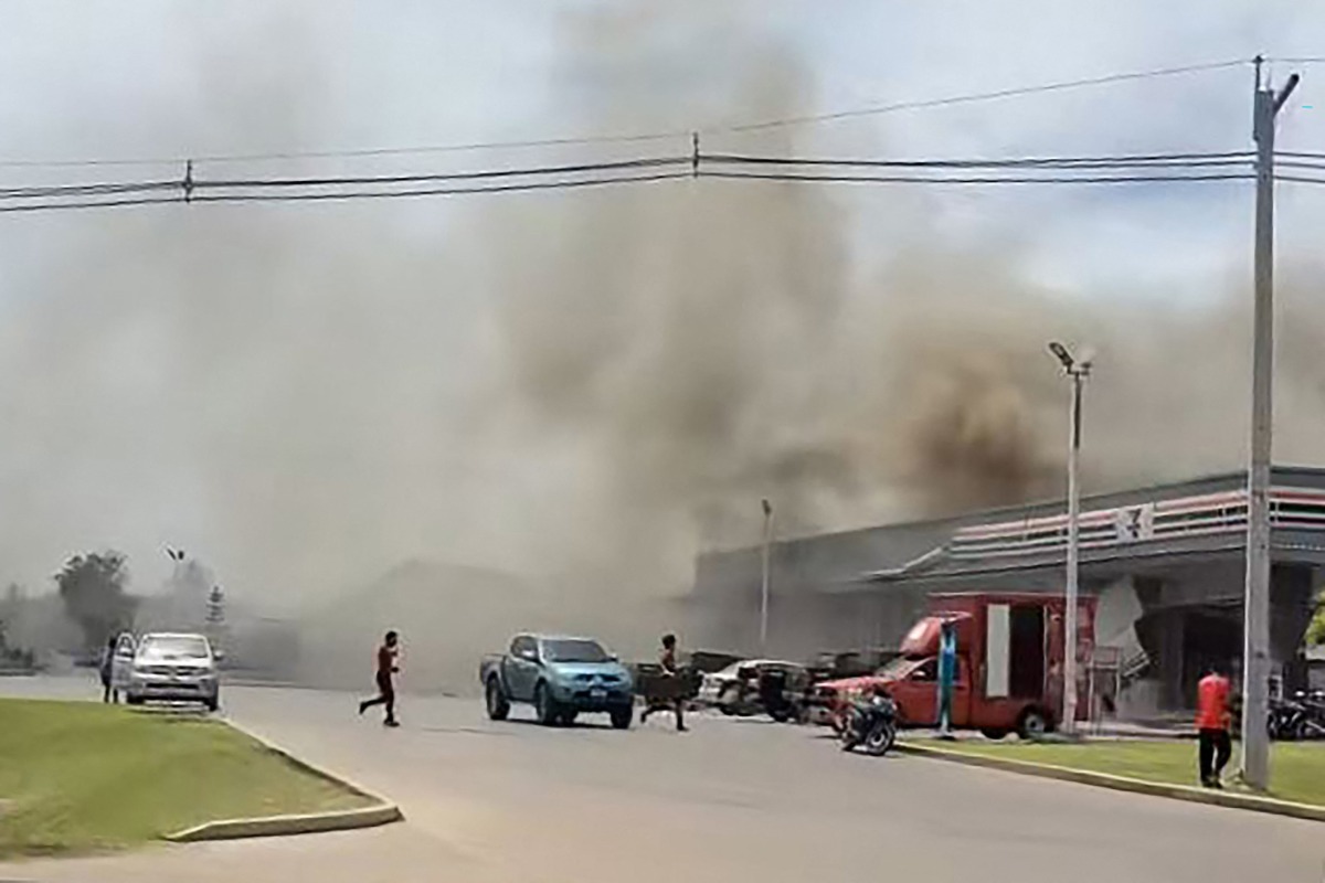 This frame grab from UGC video footage taken and posted on Facebook by Chatchak Ratsamikaeo on July 24, 2025 shows smoke billowing from the roof of a convenience store attached to a petrol station in Sisaket province after it was hit by a rocket strike from Cambodia. Photo by Courtesy of Facebook user Chatchak Ratsamikaeo / AFP