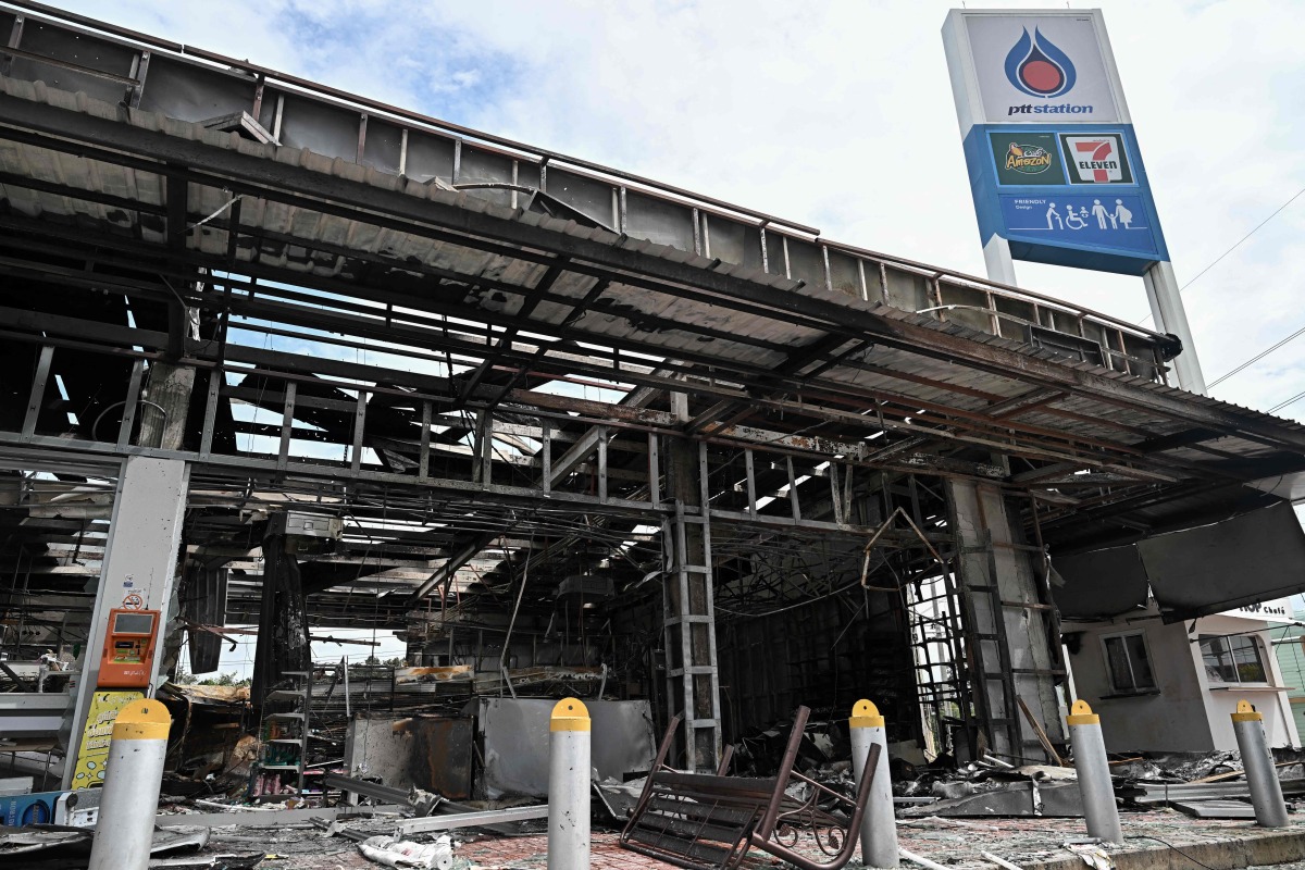 Damage from a fire caused by Cambodian artillery at a 7-11 convenience store is seen at a PTT gas station in the Thai border province of Sisaket province on July 25, 2025. (Photo by Lillian SUWANRUMPHA / AFP)

