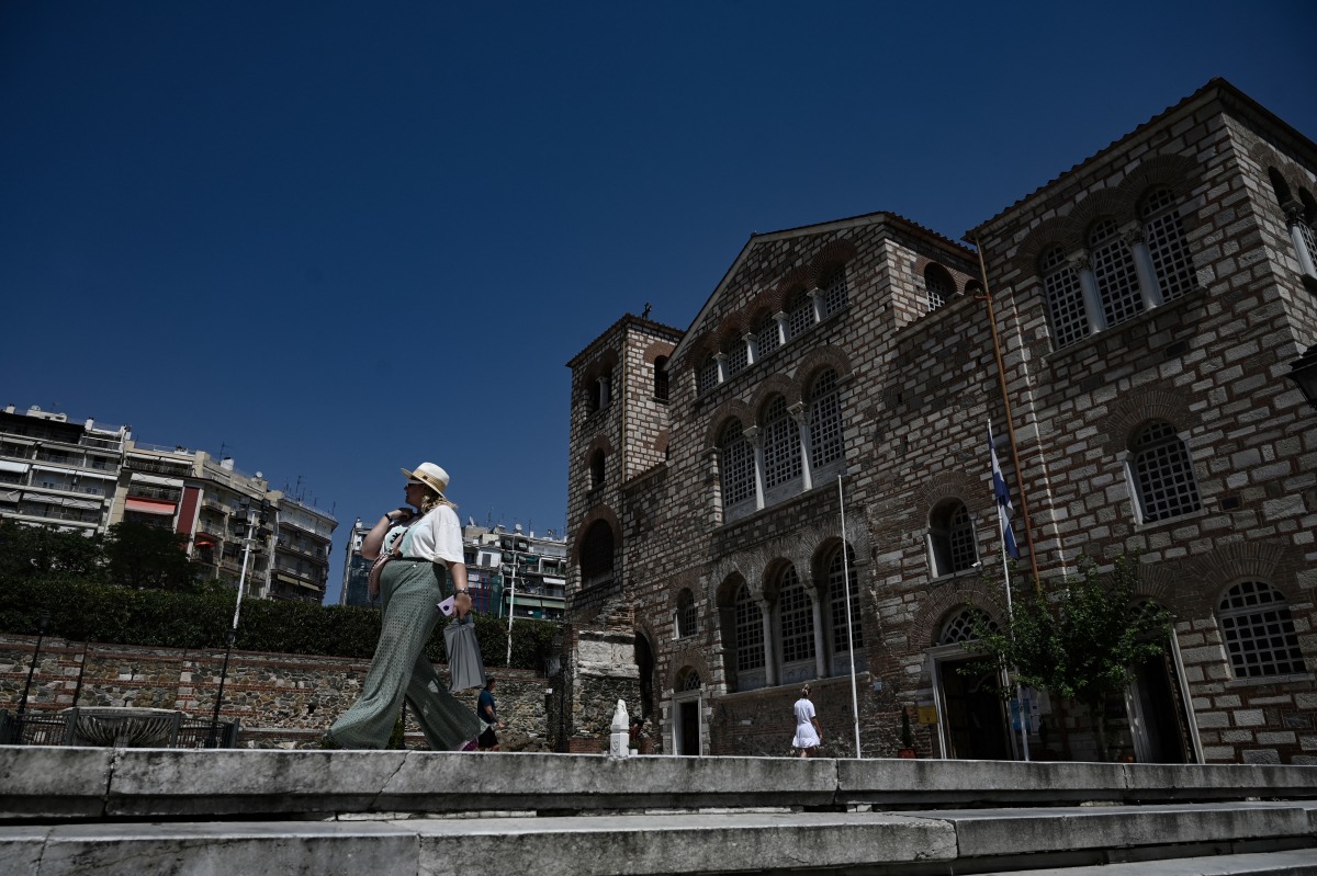 Photo used for representational purposes. A pedestrian walks near the church Agios Dimitrios during a heatwave in Thessaloniki on July 24, 2025. Photo by Sakis Mitrolidis / AFP.
