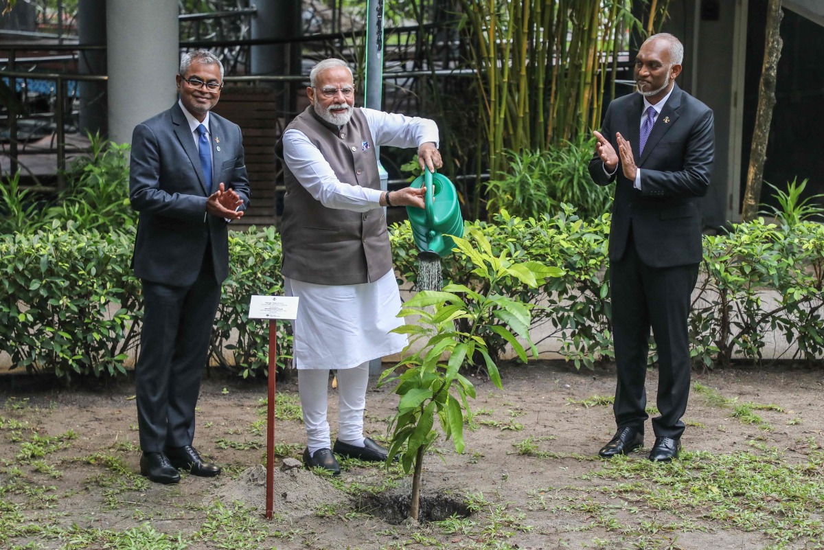 The President of Maldives Mohamed Muizzu (R) reacts as India's Prime Minister Narendra Modi (C) plants a tree sapling during his state visit in Male on July 25, 2025. (Photo by Mohamed Afrah / AFP)
