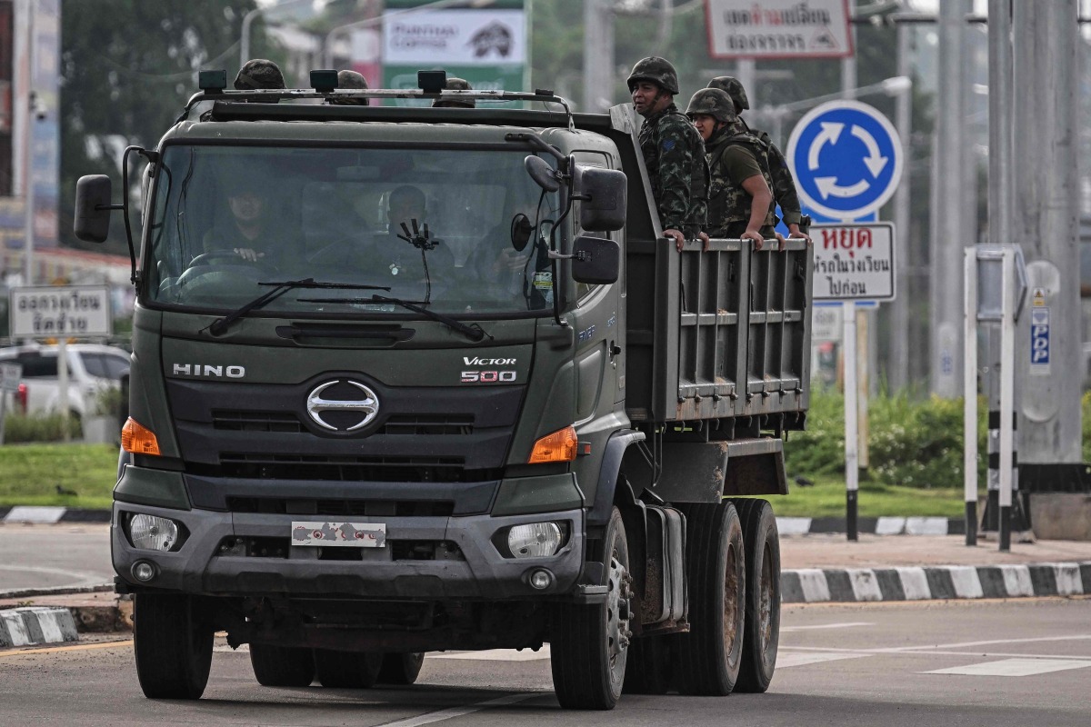 Royal Thai Army soldiers are transported on the back of an army truck in the Thai border province of Si Sa Ket on July 26, 2025. (Photo by Lillian SUWANRUMPHA / AFP)
