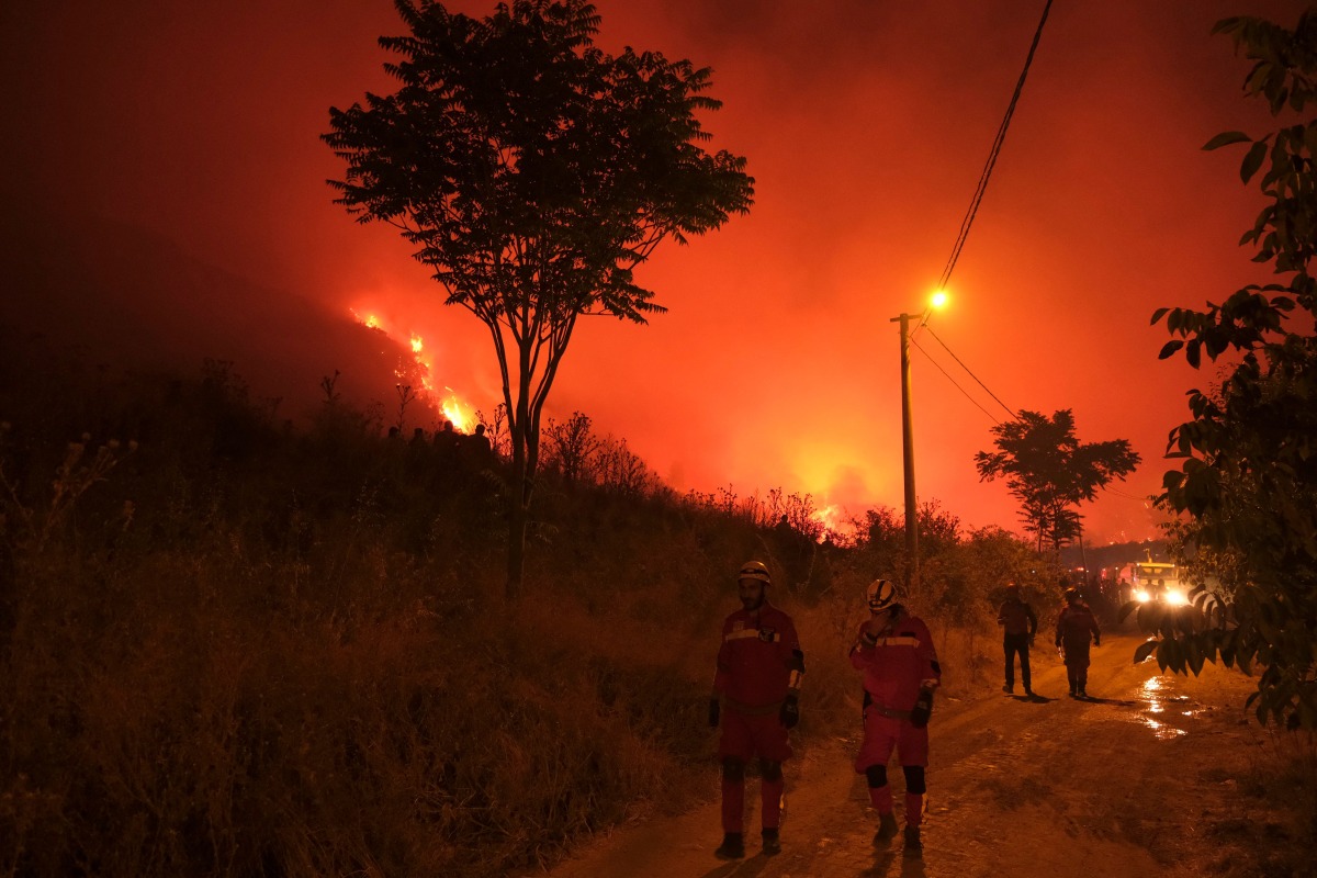 Firefighters attempt to extinguish a wildfire as smoke and flames rise from a forested area in the Gursu district of Bursa early on July 27, 2025. (Photo by ONUR YURTSEVER / AFP)