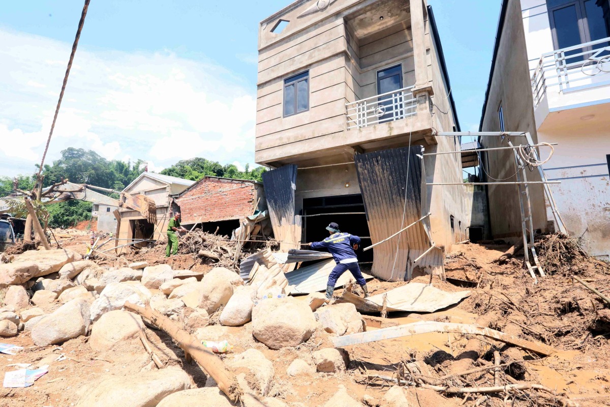 This photo taken by the Vietnam News Agency (VNA) on July 28, 2025 shows rescue workers clearing debris following flash floods in Son La province in northern Vietnam. Photo by Vietnam News Agency / AFP