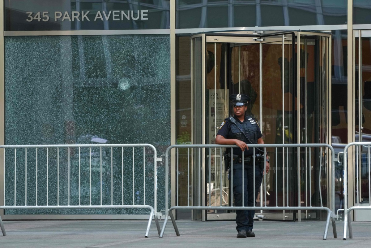 A New York City Police (NYPD) officer stands outside the 345 Park Avenue building, the scene of last night's deadly shootings in Midtown Manhattan in New York on July 29, 2025. (Photo by TIMOTHY A. CLARY / AFP)
