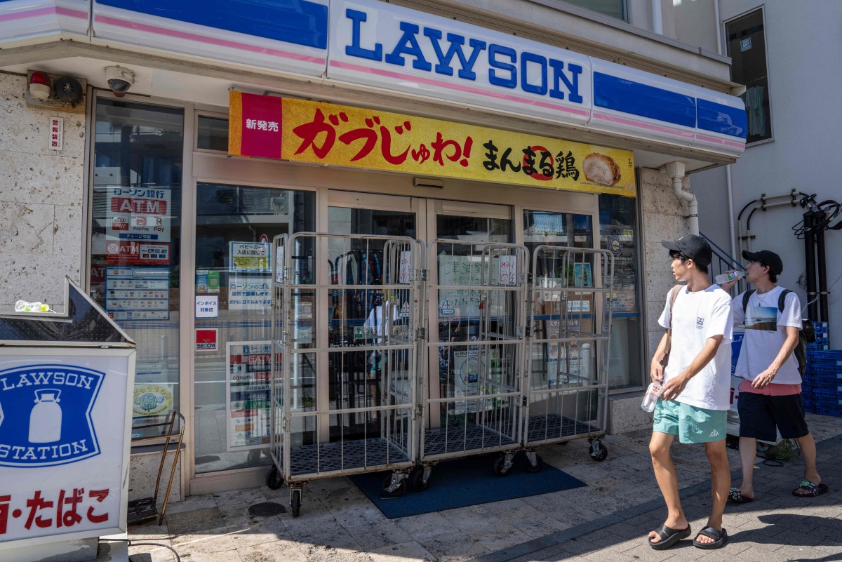 People walk past a convenience store which is closed due to a tsunami warning in Fujisawa city, Kanagawa prefecture on July 30, 2025. Photo by Yuichi YAMAZAKI / AFP