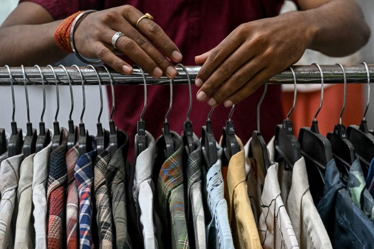 An employee arranges shirts at the apparel manufacturing unit at Bhiwandi in the Thane district of India's Maharashtra state on July 30, 2025. (Photo by Indranil MUKHERJEE / AFP)
