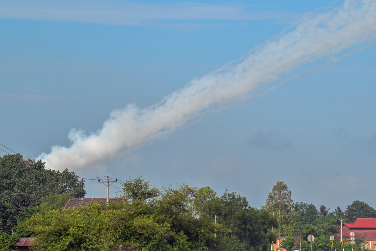Smoke is pictured in the air from a multi-rocket launcher near the Cambodia-Thailand border in Oddar Meanchey province on July 25, 2025. (Photo by TANG CHHIN Sothy / AFP)
