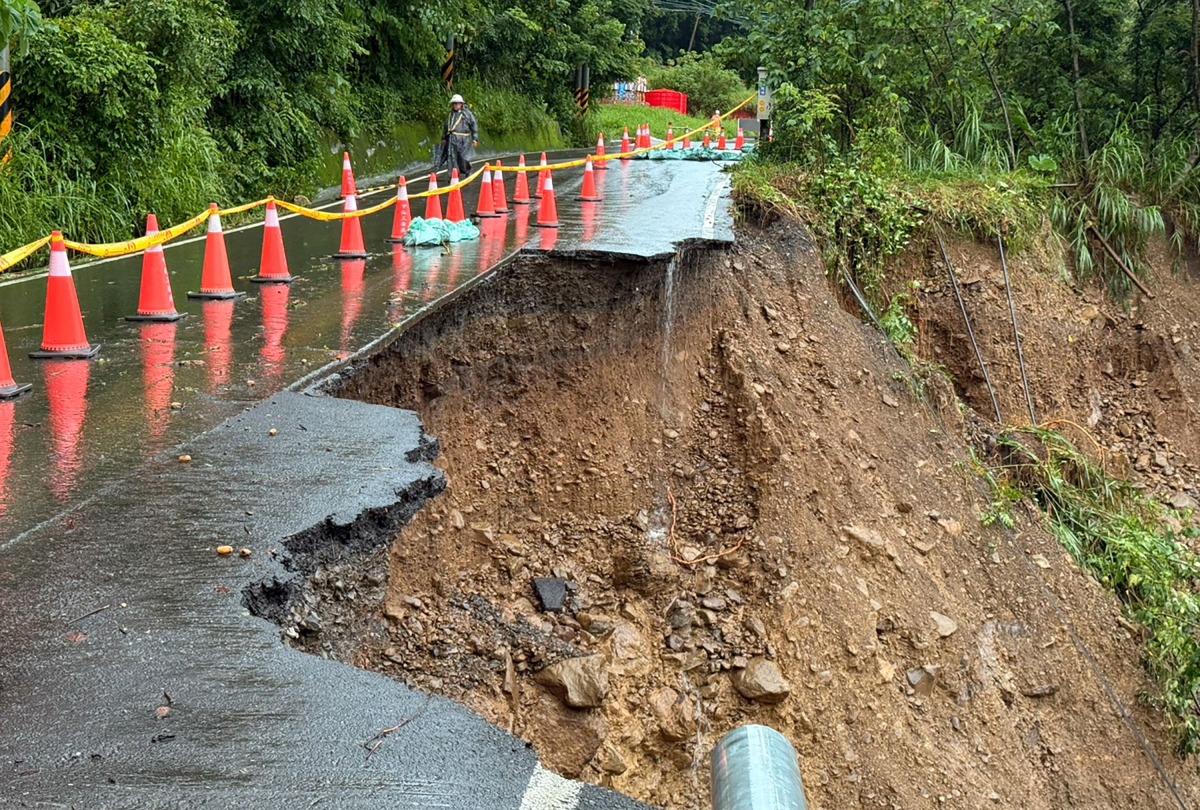 This handout taken on August 3, 2025 and released by the Kaohsiung Fire Department shows a landslide that swept away a section of road, which caused a car transporting five people to plunge into a ravine, in a mountainous area of Kaohsiung. Photo by Handout / Kaohsiung Fire Department / AFP