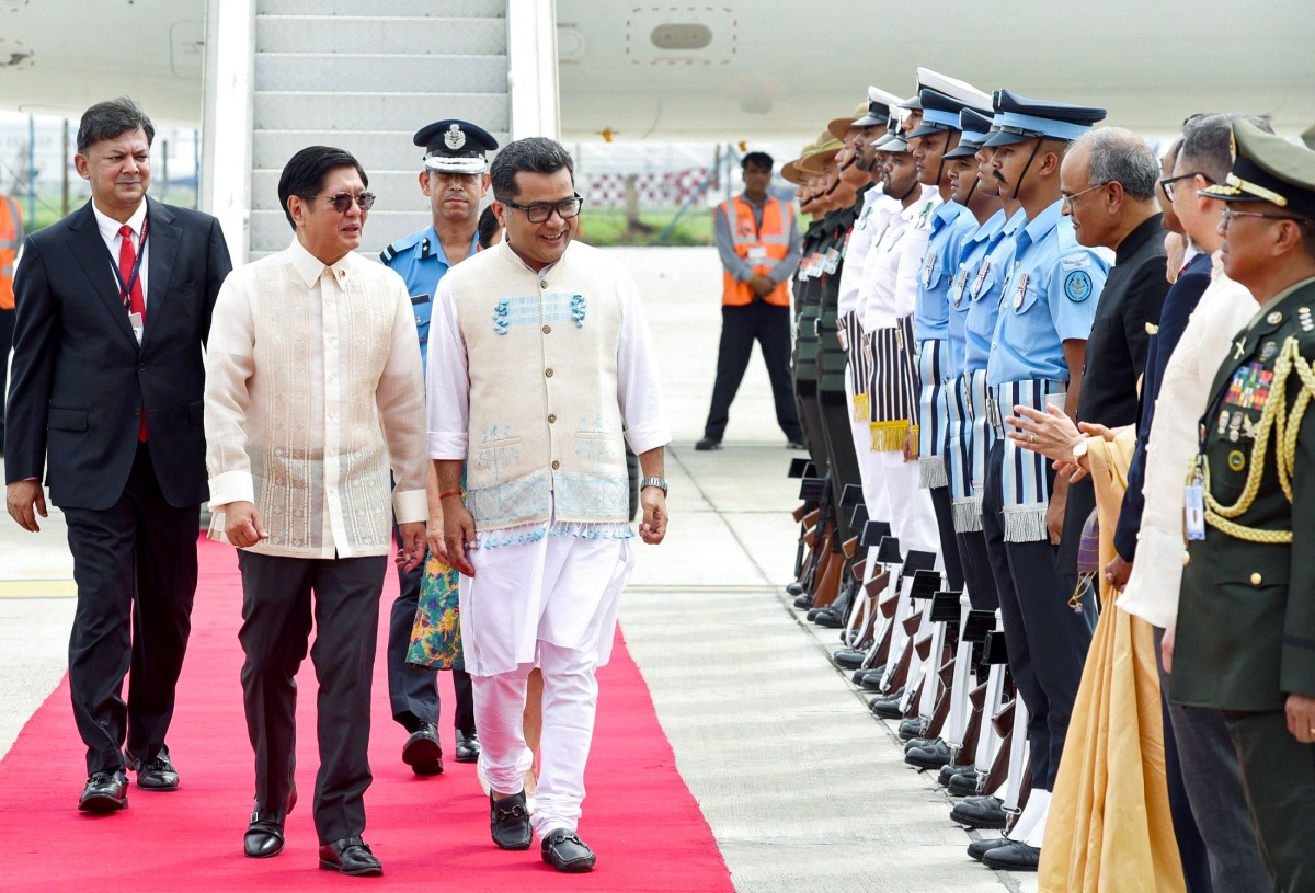 In this handout photograph taken on August 4, 2025 and released by the Indian Press Information Bureau (PIB), Philippines' President Ferdinand Marcos (2L) walks alongside India's Minister of State for External Affairs Pabitra Margherita (C) as he inspects the honour guards upon his arrival at the airport in New Delhi. Photo by Indian Press Information Bureau (PIB) / AFP