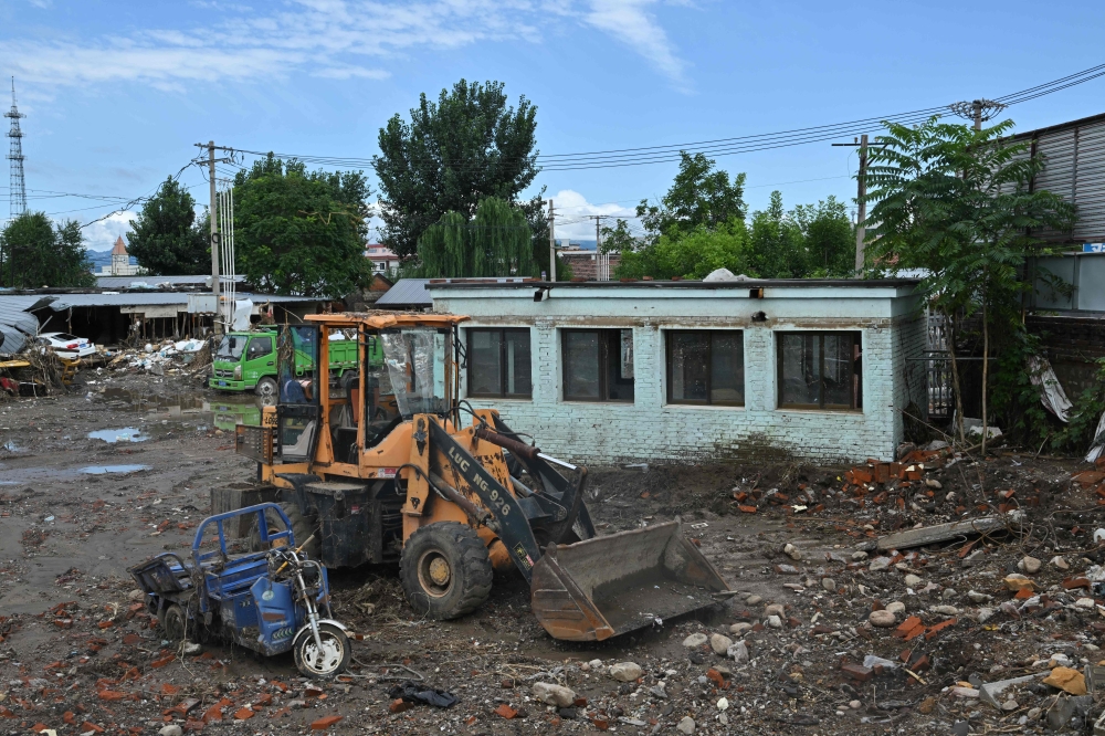 Damaged vehicles are seen following deadly flooding in Taishitun village, Miyun district, Beijing on August 5, 2025. (Photo by Adek Berry / AFP)