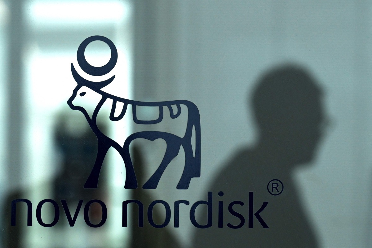 An employee walks past a door bearing the logo of Novo Nordisk at the factory in Hilleroed on September 26, 2023. Photo by Sergei GAPON / AFP