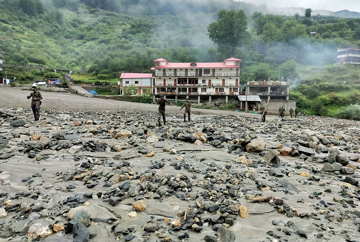 This handout photograph released on August 6, 2025 by the Indian Army shows security and relief personnel preparing to build a crossing across a stream of dense sludge and rocks during a search and rescue operation, a day after a cloudburst caused a massive mudslide and flash floods in India's Uttarakhand state. Photo by Indian Army / AFP