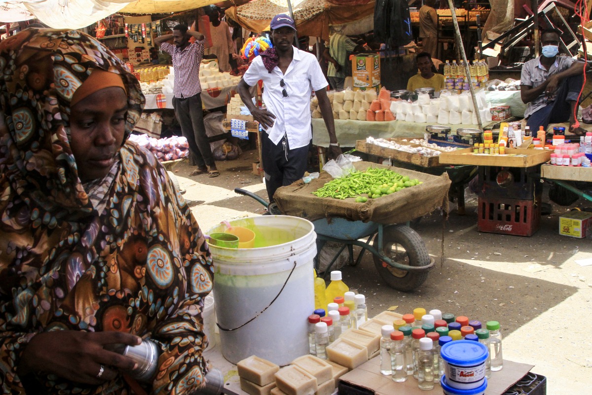 File: Sudanese people sell goods at an open market in the East Nile district of Khartoum on May 19, 2025. (Photo by Ebrahim Hamid / AFP)