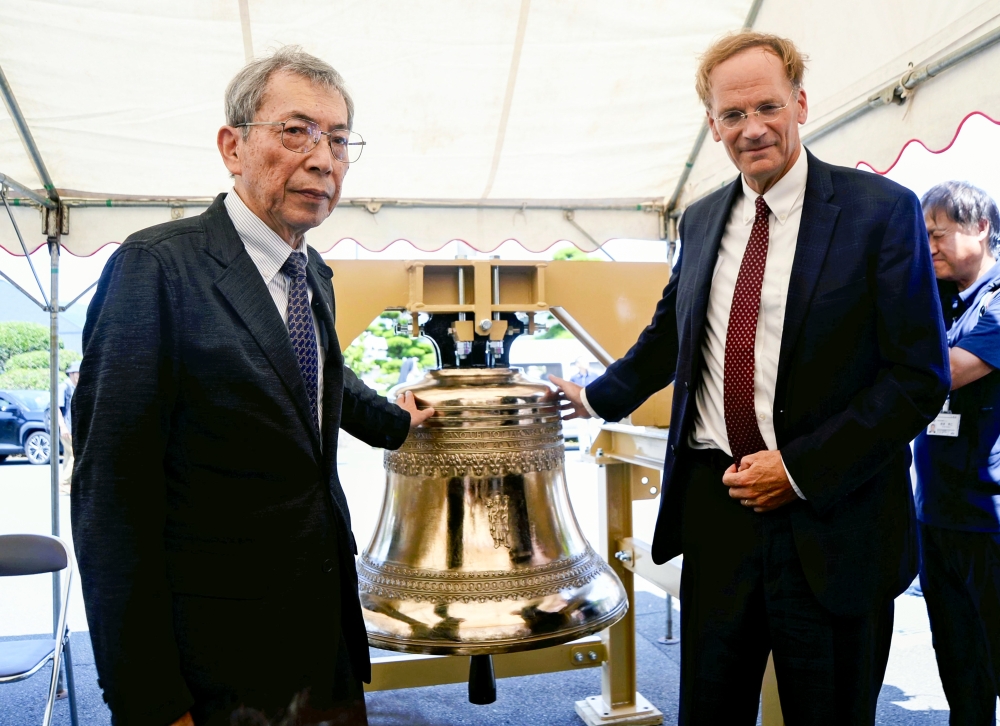 Kojiro Moriuchi, left, and James L Nolan Jr are seen beside a new bell at Urakami Cathedral in Nagasaki on July 17. (The Japan News)
