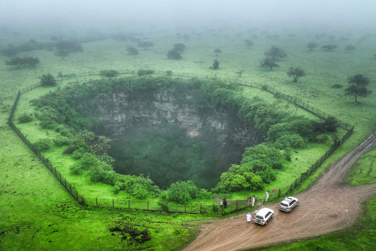 An aerial picture shows a view of the Sheeheet sinkhole in Oman's Dhofar region near the city of Taqah on July 25, 2025. (Photo by AFP)
