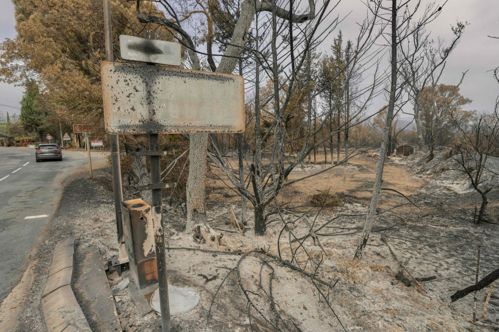 This photograph shows a burned entrance sign following wildfires in Durban-Corbieres, in the Aude department, southern France on August 9, 2025. (Photo by Idriss Bigou-Gilles / AFP)