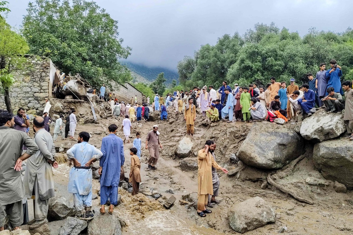 People gathered at the site of a flashflood in Salarzai Tehsil of Pakistan's Bajaur district on August 15, 2025. Photo by AFP