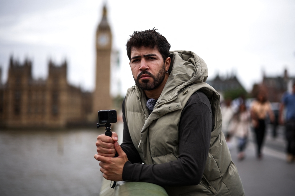 Diego Galdino, who hunts and films pickpockets in London and posts the footage on social media, poses on Westminster Bridge in London on August 7, 2025. (Photo by Henry Nicholls / AFP)